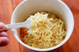 fideos instantáneos hervidos, cocine fideos ramen instantáneos en una taza - sopa de fideos en un tazón de papel foto