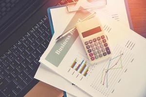gráfico de informe comercial preparación de gráficos calculadora en computadora portátil informe resumido en estadísticas círculo gráfico circular en papel foto