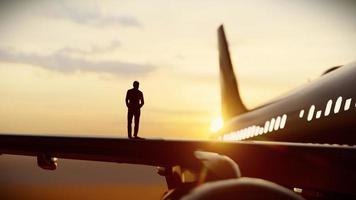 silueta de un exitoso hombre de negocios parado en un ala de avión privado, representación 3d. foto