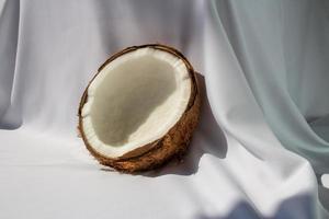 concepto de fruta tropical, mitades de coco blanco fresco sobre fondo de tela blanca