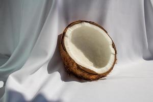 concepto de fruta tropical, mitades de coco blanco fresco sobre fondo de tela blanca