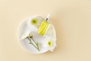 top view of a transparent dropper vial with a natural organic product for face and body skin care. organic serum. beige background. photo