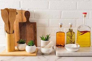 Front view of the storage area of various bottles of oil for cooking and various utensils in the modern kitchen. eco items. photo