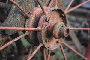 vieja rueda de metal oxidado con radios para trabajo en agricultura foto