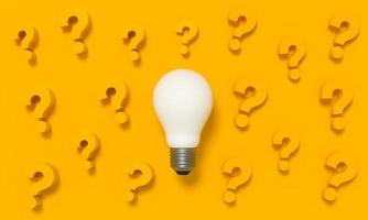 Light Bulb with question mark around on yellow background. photo