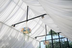 Wedding bridal decorations. Bottom view of blooming flower archery, bouquet cmposition on a ceiling. photo