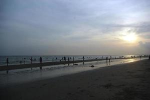 sea with evening sun Many tourists fill the beach. photo