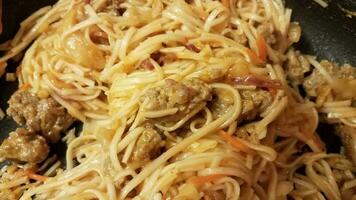 sausage meat and spaghetti in a frying pan photo