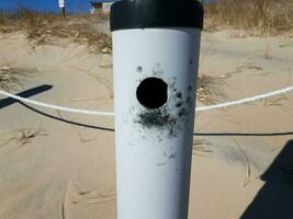 metallic cigarette smoking trash can at beach with sand photo