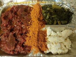 Ethiopian kitfo raw beef in tray with cheese and greens and spices photo