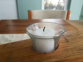 white candle in a wooden holder on a table photo