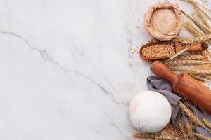 Wheat ears and wheat grains set up on marble background. Top view and copy space photo