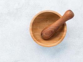 Top view of bamboo mortar and pestle set up on white concrete background. photo