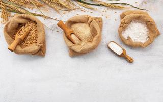 Wheat ears and wheat grains set up on white stone background. photo