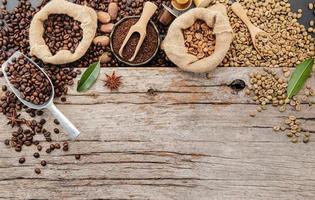 Background of various coffee , dark roasted coffee beans , ground and capsules with scoops setup on wooden background with copy space. photo