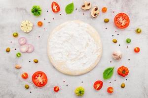 los ingredientes para la pizza casera sobre fondo de hormigón blanco. foto