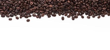 Dark roasted coffee beans setup on white background with copy space. photo