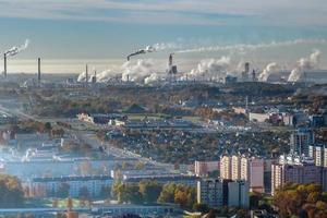 panoramic aerial view of the smoke of pipes as background of huge residential complex with high-rise buildings and private sector . Air and water pollution concept photo