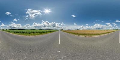 vista panorámica hdri 360 esférica sin costuras en carretera asfaltada sin tráfico entre campos con cielo nublado y nubes blancas en proyección equirectangular, puede usarse como reemplazo del cielo en panoramas foto