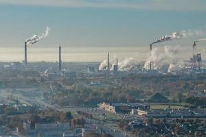 panoramic aerial view of the smoke of pipes as background of huge residential complex with high-rise buildings and private sector . Air and water pollution concept photo