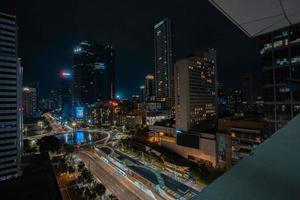 Night cityscape,and traffic light of highway in slow speed shutter motion effect and noise.Jakarta, Indonesia .January 9 2023 photo