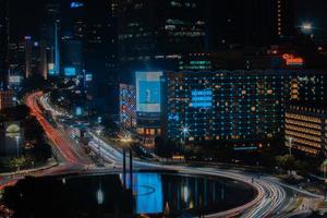 Night cityscape,and traffic light of highway in slow speed shutter motion effect and noise.Jakarta, Indonesia .January 9 2023 photo