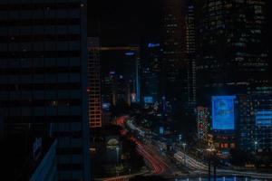 Night cityscape,and traffic light of highway in slow speed shutter motion effect and noise.Jakarta, Indonesia .January 9 2023 photo