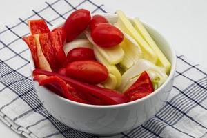 Fresh and raw vegetables for Italian Pinzimonio on white wooden table. Pinzimonio is often served as starter before a main meal. photo