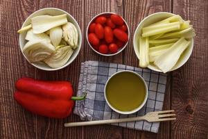Fresh and raw vegetables for Italian Pinzimonio on white wooden table. Pinzimonio is often served as starter before a main meal. Top view. Flat lay. photo