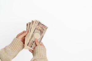 Woman hand holding Japanese Yen banknote stack. Thousand Yen money. Japan cash, Tax, Recession Economy, Inflation, Investment, finance and shopping payment concepts photo