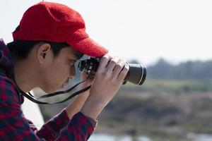 Asian boy is using binoculars to do the birds' watching in tropical forest during summer camp, idea for learning creatures and wildlife animals and insects outside the classroom. photo