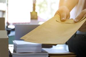 Soft focus of office clerk or secretary is preparing documents and brown envelopes for those interested in bidding for the construction of a large building in an office. photo