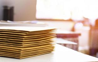 Soft focus of office clerk or secretary is preparing documents and brown envelopes for those interested in bidding for the construction of a large building in an office. photo