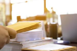 Soft focus of office clerk or secretary is preparing documents and brown envelopes for those interested in bidding for the construction of a large building in an office. photo