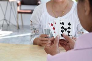 juego de cartas de personas mayores en casa en su tiempo libre, recreación y felicidad del concepto de personas mayores. foto