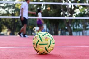 pelota sepak takraw en el piso rojo de la cancha al aire libre, fondo borroso, actividad recreativa y deportes al aire libre en el concepto de países del sudeste asiático. foto