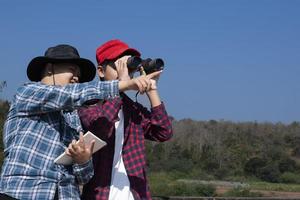 los niños asiáticos están usando binoculares para observar aves en el bosque tropical durante el campamento de verano, idea para aprender criaturas y animales salvajes e insectos fuera del aula. foto