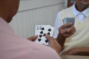 juego de cartas de personas mayores en casa en su tiempo libre, recreación y felicidad del concepto de personas mayores. foto