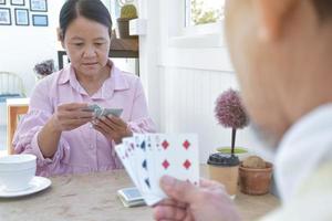 juego de cartas de personas mayores en casa en su tiempo libre, recreación y felicidad del concepto de personas mayores. foto