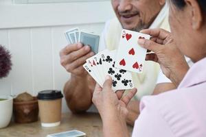 juego de cartas de personas mayores en casa en su tiempo libre, recreación y felicidad del concepto de personas mayores. foto