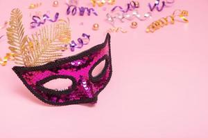 Festive face mask for masquerade or carnival celebration on colored background. Copy space photo