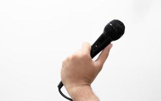 mano sujetando un micrófono aislado sobre fondo blanco. foto