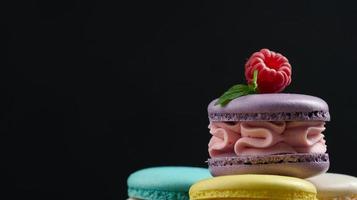 Baked macaroons on black background, copy space photo