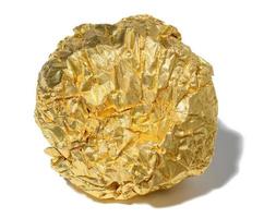 Crumpled piece of golden foil with shadow on a white isolated background photo