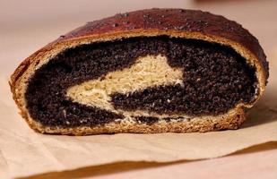 Baked roll with poppy seeds on the table photo