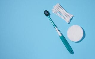 Toothbrush, round cotton sponges and cotton buds on a blue background, hygiene products photo