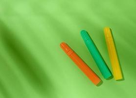 Multicolored felt-tip pens on a green background photo