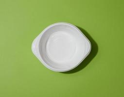 White empty plastic soup bowl on green background, top view photo