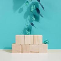 Podium from wooden cubes and a branch with leaves. Stage for the demonstration of cosmetic products photo