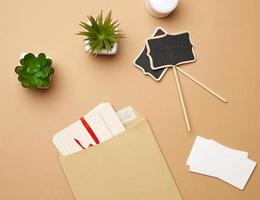 brown paper envelope and empty wooden pointer on a brown background photo